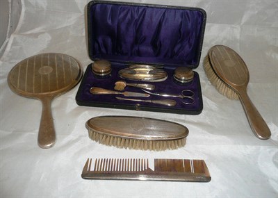 Lot 487 - A George V silver backed vanity set, with engine turned decoration, comprising hand mirror,...