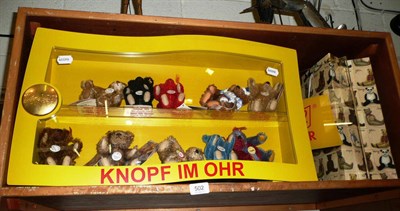 Lot 502 - Ten miniature Steiff bears in display cabinet and an advertising sign
