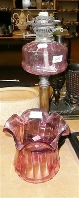 Lot 520 - Cranberry glass and brass table oil lamp and shade