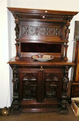 Lot 566 - A carved oak cabinet with an open shelf top