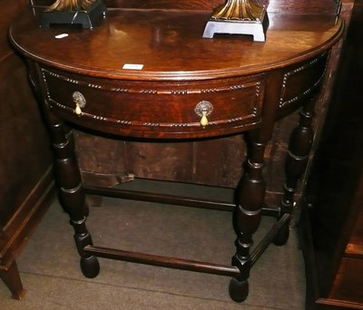 Lot 604 - A carved oak demi-lune hall table