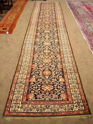 Lot 880 - Malayir Rug West Persia The deep indigo field with a column of linked floral medallions...