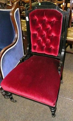 Lot 656 - An ebonised nursing chair with red velvet button back and seat