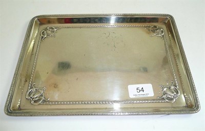 Lot 54 - A rectangular silver dressing table tray with embossed floral spandrels