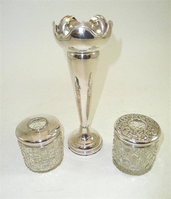 Lot 130 - A silver bud vase and two silver topped hair tidies