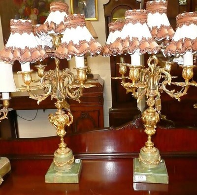 Lot 133 - A pair of onyx and ormolu four branch candlesticks, fitted for electricity