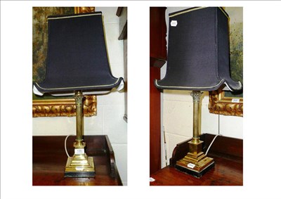 Lot 139 - A pair of decorative brass Corinthian column table lamps with black shades