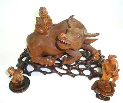 Lot 231 - A Chinese carved wooden water buffalo figure group on stand, two smaller wooden figures, inlaid...