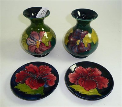 Lot 250 - Two Walter Moorcroft Clematis pattern vases and two Walter Moorcroft Hibiscus pattern plates(4)