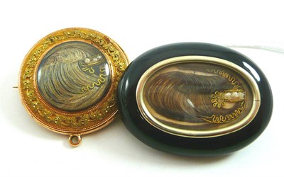 Lot 341 - A jet mourning brooch with hair inset locket and a double sided locket with hair inset