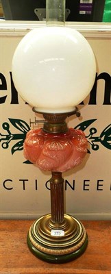 Lot 372 - An Art Nouveau oil lamp with red opaque glass font and earthenware socle