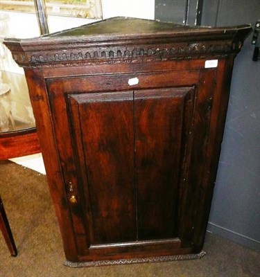 Lot 528 - An oak straight fronted wall hanging corner cabinet