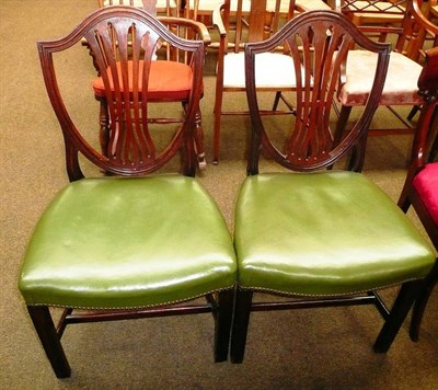 Lot 590 - Two George III mahogany shield back dining chairs with leather over stuffed seats