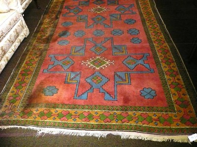 Lot 662 - A Turkish lesghi design rug; the candy pink field with two typical stellar medallions enclosed...