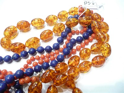 Lot 148 - A coral necklet, a lapis lazuli necklet and an amber necklet