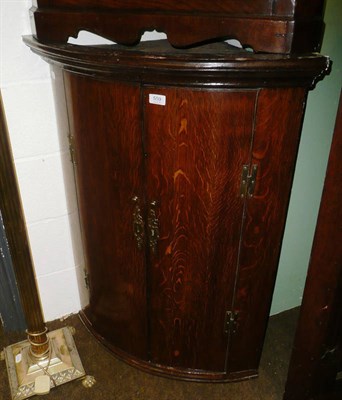 Lot 559 - A Georgian oak bow fronted corner cupboard