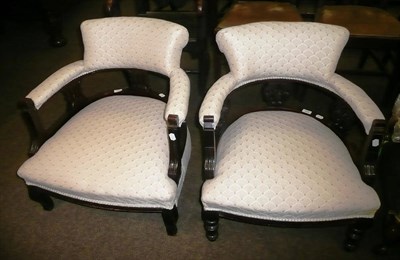 Lot 635 - A pair of late Victorian tub shaped low armchairs upholstered in cream weave