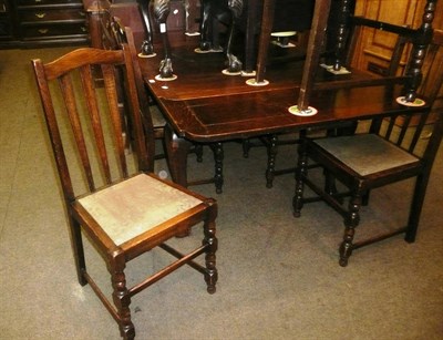 Lot 672 - An early 20th century oak draw leaf dining table and six chairs including two carvers