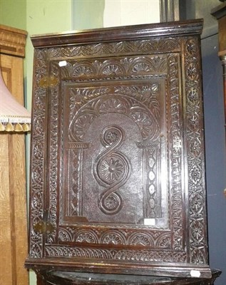 Lot 677 - An carved oak corner cupboard