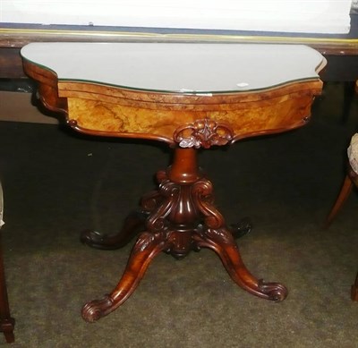 Lot 704 - A Victorian carved walnut fold-over pedestal card table