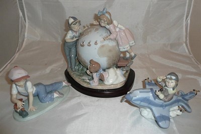 Lot 201 - Three Lladro groups including a figural group of three children and a globe, figure of a young...