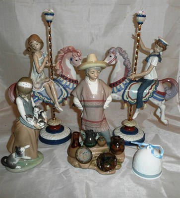 Lot 202 - Two Lladro groups of children on a merry go round, a figure of a young girl with an armful of...