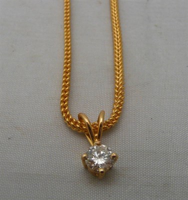 Lot 234 - A diamond solitaire pendant on foxtail link chain