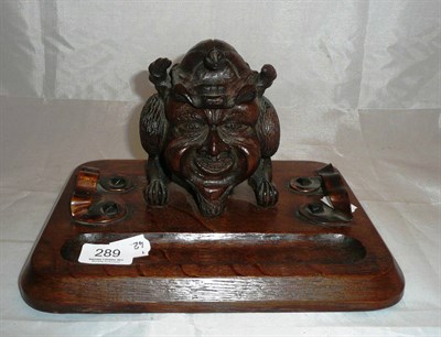 Lot 289 - Carved oak inkstand modelled with a 'demon' faced inkwell