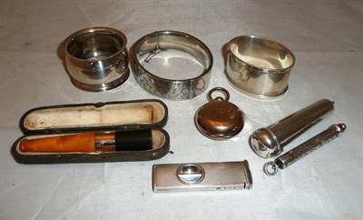 Lot 469 - Hinged silver bangle, two silver napkin rings, silver cigar cutter, silver cheroot case,...