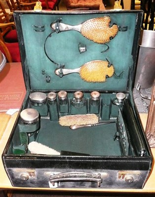 Lot 485 - Leather suitcase with silver-topped dressing items