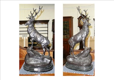 Lot 491 - After Moigniez - a pair of modern bronzed metal figures of Stags, each standing on an upswept rocky