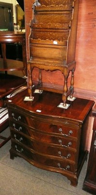 Lot 655 - An oak four tier paper rack on stand and a reproduction serpentine mahogany chest