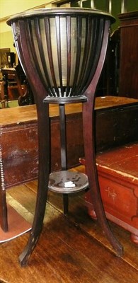 Lot 755 - A mahogany plant stand with brass liner