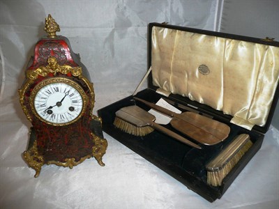 Lot 85 - A boulle mantel clock (a.f.) and a silver three piece dressing table set
