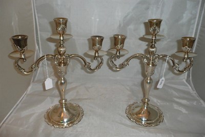Lot 107 - A pair of white metal Mexican two-branch candlesticks