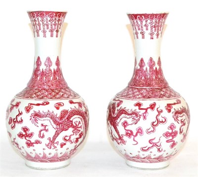 Lot 84 - A Pair of Chinese Porcelain Bottle Vases, with flared necks, painted in red with dragons...