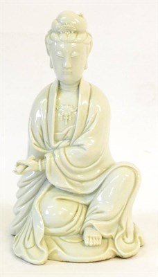 Lot 90 - A Blanc de Chine Figure of Guanyin, sitting wearing long robes, a scroll in her left hand,...