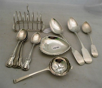 Lot 397 - A silver toast rack, three silver spoons, four silver teaspoons and a silver tea strainer and a...