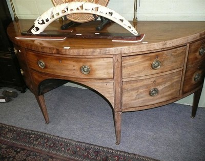 Lot 630 - A Regency mahogany bow-fronted sideboard with brass gallery rail, reduced in height