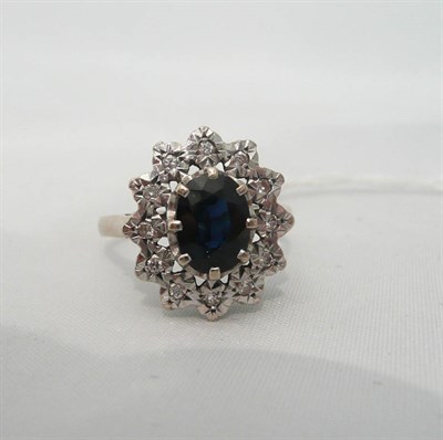 Lot 82 - An 18ct white gold sapphire and diamond cluster ring
