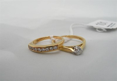 Lot 101 - An 18ct gold diamond solitaire ring and an 18ct gold half eternity ring