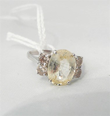Lot 106 - A 14ct white gold yellow sapphire and diamond ring