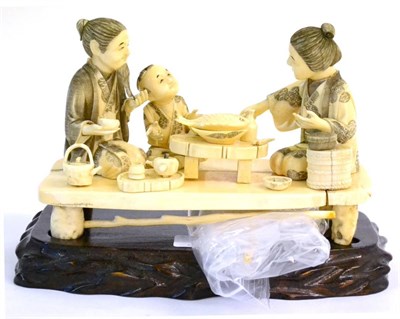 Lot 132 - A Japanese Marine Ivory Okimono, Meiji period, as a family eating, the three figures kneeling about