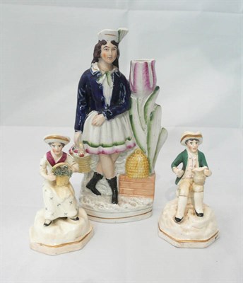 Lot 125 - A pair of Staffordshire figures and another Staffordshire figural candle holder