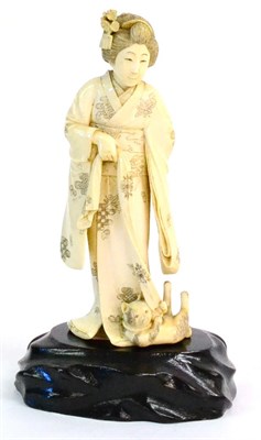 Lot 134 - A Japanese Ivory Okimono, circa 1900, depicting a Bijin wearing traditional robes, her hair...
