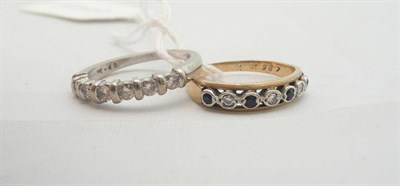 Lot 310 - A 9ct white gold diamond half eternity ring and a sapphire and diamond half eternity ring (2)