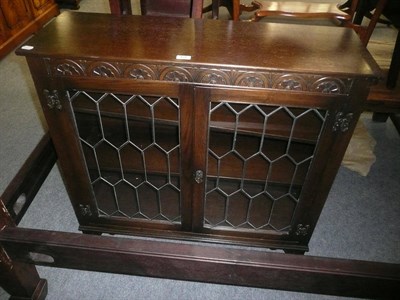 Lot 476 - An oak bookcase with leaded glazed doors