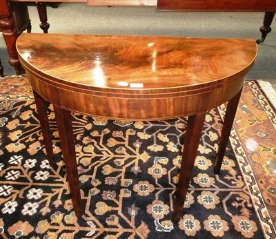 Lot 496 - A 19th century mahogany inlaid demi lune fold over tea table