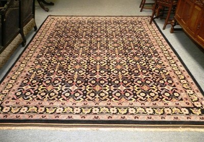 Lot 523 - An Indian carpet, Uttar Pradesh, the indigo field with columns of serrated leaves enclosed by...