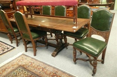 Lot 524 - An extending oak dining table and six carved oak upholstered chairs